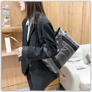 Silver-gray quilted puffer tote bag shown on a model for casual daily style