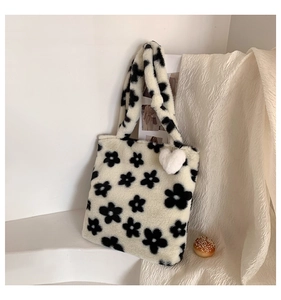 Detailed macro view of soft faux fur texture and black floral patterns on the plush tote bag