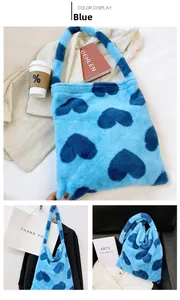 Detail view of large blue plush tote bag with navy heart pattern and soft faux fur texture