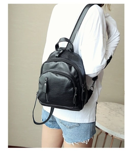 Detail of a black pebbled leather women backpack with multiple zippers and adjustable straps