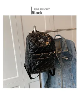 Detail of black quilted down backpack featuring large diamond stitching and metal hooks
