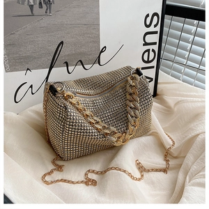 Detail of luxury rhinestone cylinder bag with gold decorative chain and crossbody strap