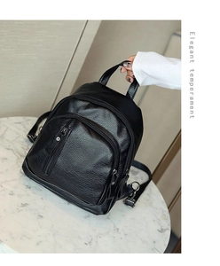 Detail of black washed leather backpack with silver zippers and lychee grain texture