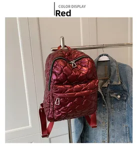 Detail view of quilted red nylon backpack with shiny diamond stitching and zipper