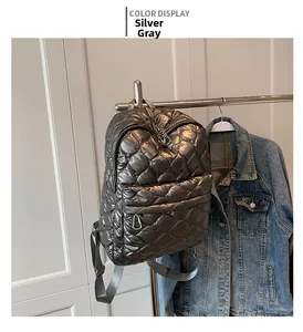 Detailed view of silver gray quilted backpack with high-shine metallic finish and zippers