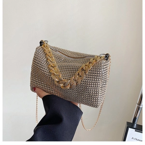 Detailed macro shot of the golden rhinestone evening bag with elegant metal chain straps