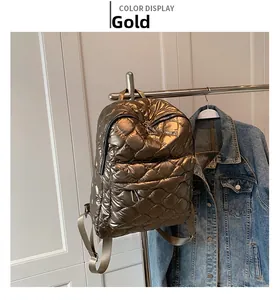 Close-up of gold quilted backpack showing metallic texture and diamond stitch details