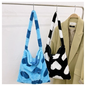 Detail of plush tote bags with heart patterns and long shoulder straps in blue and black