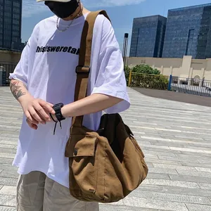 Brown canvas crossbody bag for men and women featuring a large capacity workwear style