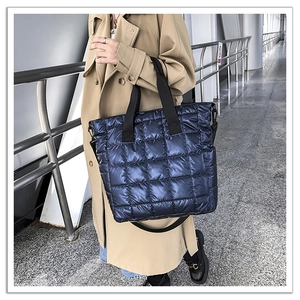 Close-up of Navy blue quilted nylon tote bag with metallic luster and square stitching