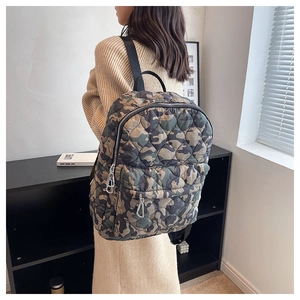 Detail of quilted camouflage backpack with durable nylon fabric and metal zippers