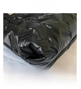 Close-up of black quilted canvas tote showing high-quality stitching and padded texture