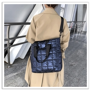 Detailed close-up of blue quilted puffer tote bag with classic lattice stitching and wide straps