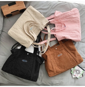 Flat lay of four colorful corduroy tote bags with adjustable straps and front pockets