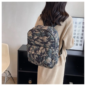 Detail of a camouflage quilted backpack with dot stitching and zipper pockets