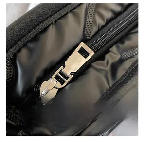 Close-up of smooth silver metal zipper on black waterproof quilted fabric handbag