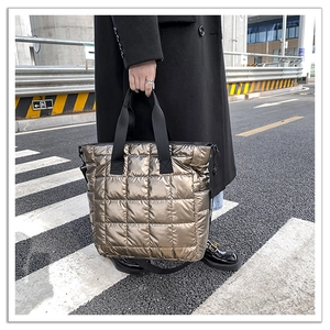 Detailed close-up of metallic bronze quilted tote bag featuring a high-gloss finish texture
