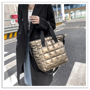 Close-up of bronze quilted puffer tote bag with durable nylon handles and metallic finish
