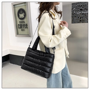 Close-up of black quilted puffer bag featuring high-gloss finish and adjustable shoulder strap