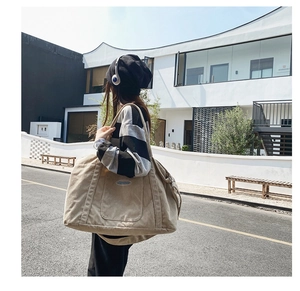 Outdoor lifestyle shot of large beige corduroy shoulder bag with textured fabric detail