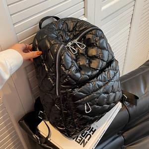 Black quilted puffer backpack for women featuring glossy large check pattern and silver zippers