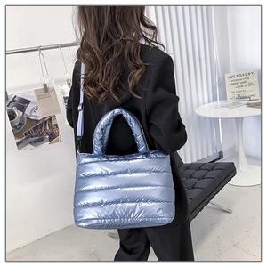 Detail of light blue puffer tote bag with metallic finish and quilted stitching pattern