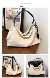 Close-up of off-white large tote bag with diamond stitching and black shoulder straps