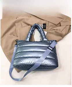 Detailed top view of light blue quilted down tote bag on trench coat background