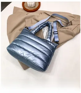 Detail of blue metallic quilted puffer bag on trench coat with a lifestyle background