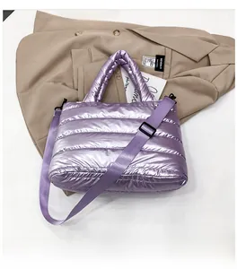 Detail of purple metallic padded tote bag with horizontal quilting and wide strap