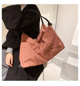 Detail view of the large pleated nylon shoulder bag showing texture and 3D silhouette
