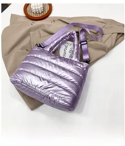 Detailed view of purple quilted nylon crossbody bag with metallic finish and top handles