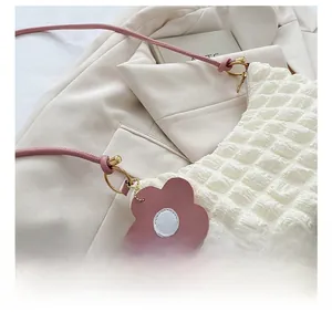 Détail du sac à main matelassé en seersucker blanc avec bandoulière rose et anneau doré