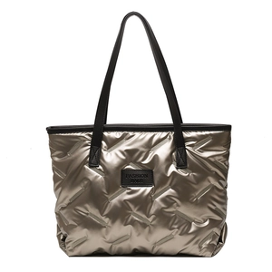 Quilted silver metallic tote bag with black leather handles and fashion logo patch