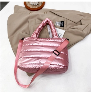 Macro detail of pink metallic padded tote bag featuring horizontal quilted seams and strap