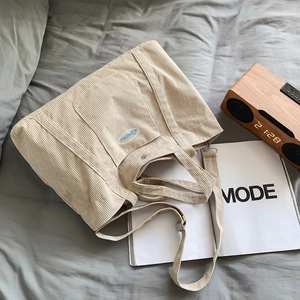 Off-white corduroy tote bag with blue embroidery and adjustable strap for women