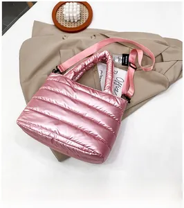 Detail of pink quilted down bag with shiny metallic finish and adjustable nylon strap