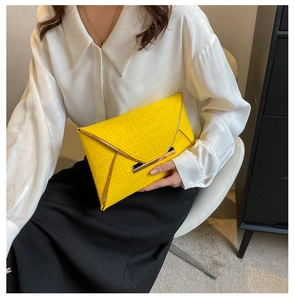 Vue détaillée de la pochette enveloppe jaune texture crocodile avec garniture dorée