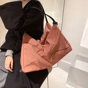 Minimalist large capacity tote bag in brick red nylon with black shoulder strap