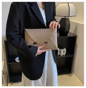 Détail de la pochette enveloppe kaki avec texture crocodile et boucle en métal doré