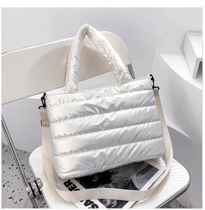 Detail of the high-gloss metallic finish and wide quilted texture on this white puffer bag
