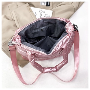 Detailed interior of pink quilted crossbody bag showing compartments and gray lining