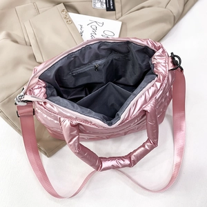 Detail showing the internal structure with a zipper pocket and pink quilted glossy fabric