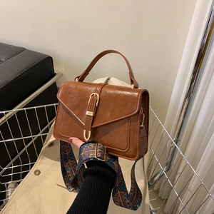 Vintage brown leather square handbag with golden buckle and patterned shoulder strap
