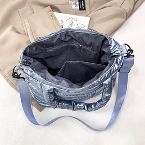 Interior detail of purple quilted puffer bag featuring a zipper pocket and smooth lining