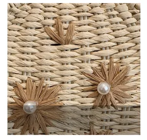 Gros plan du sac en paille avec fleurs faites main et décorations en perles