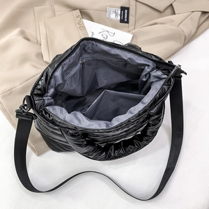 Internal view of black quilted puffer tote bag with spacious gray lining and zipper pocket