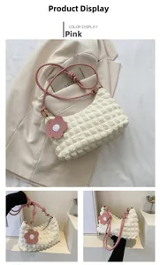 Détail du sac à main blanc à texture bulles avec bandoulière rose et pendentif fleur