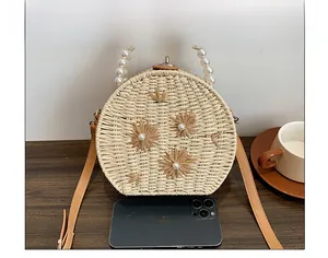 Capacité intérieure du sac rond en paille avec anse en perles et décor de marguerites
