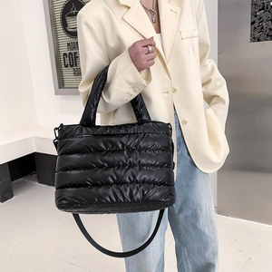 Quilted black puffer tote bag in glossy nylon with top handles and adjustable shoulder strap